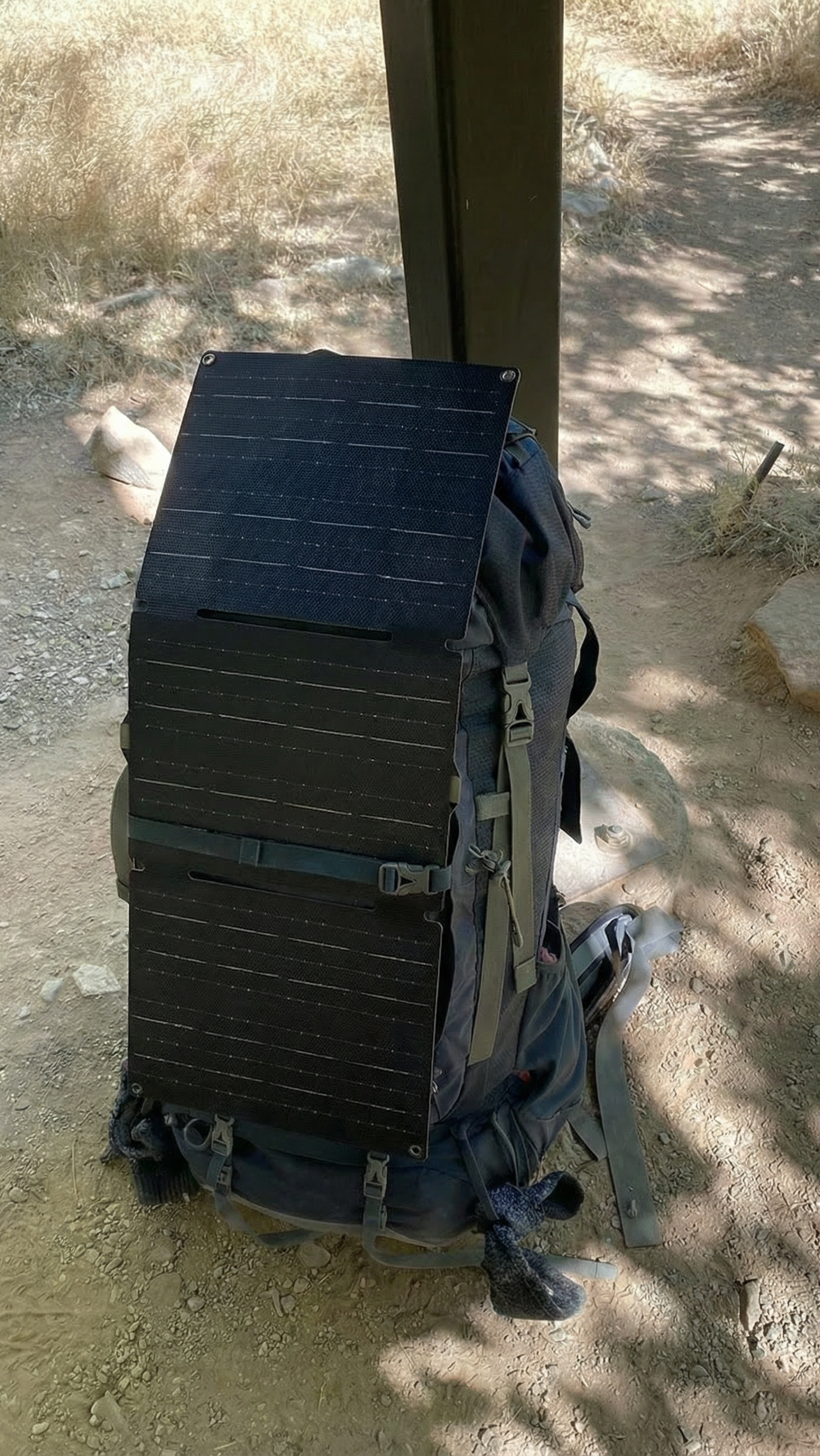 Backpack with solar panels attached on a sandy ground