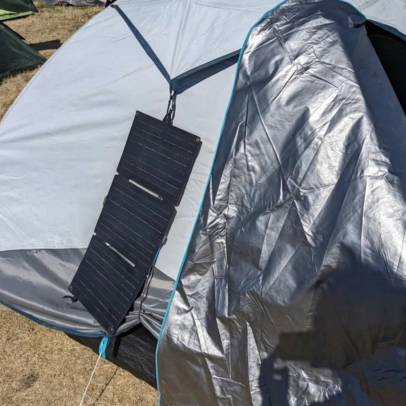 Camping tent with solar panel attached on a grassy ground