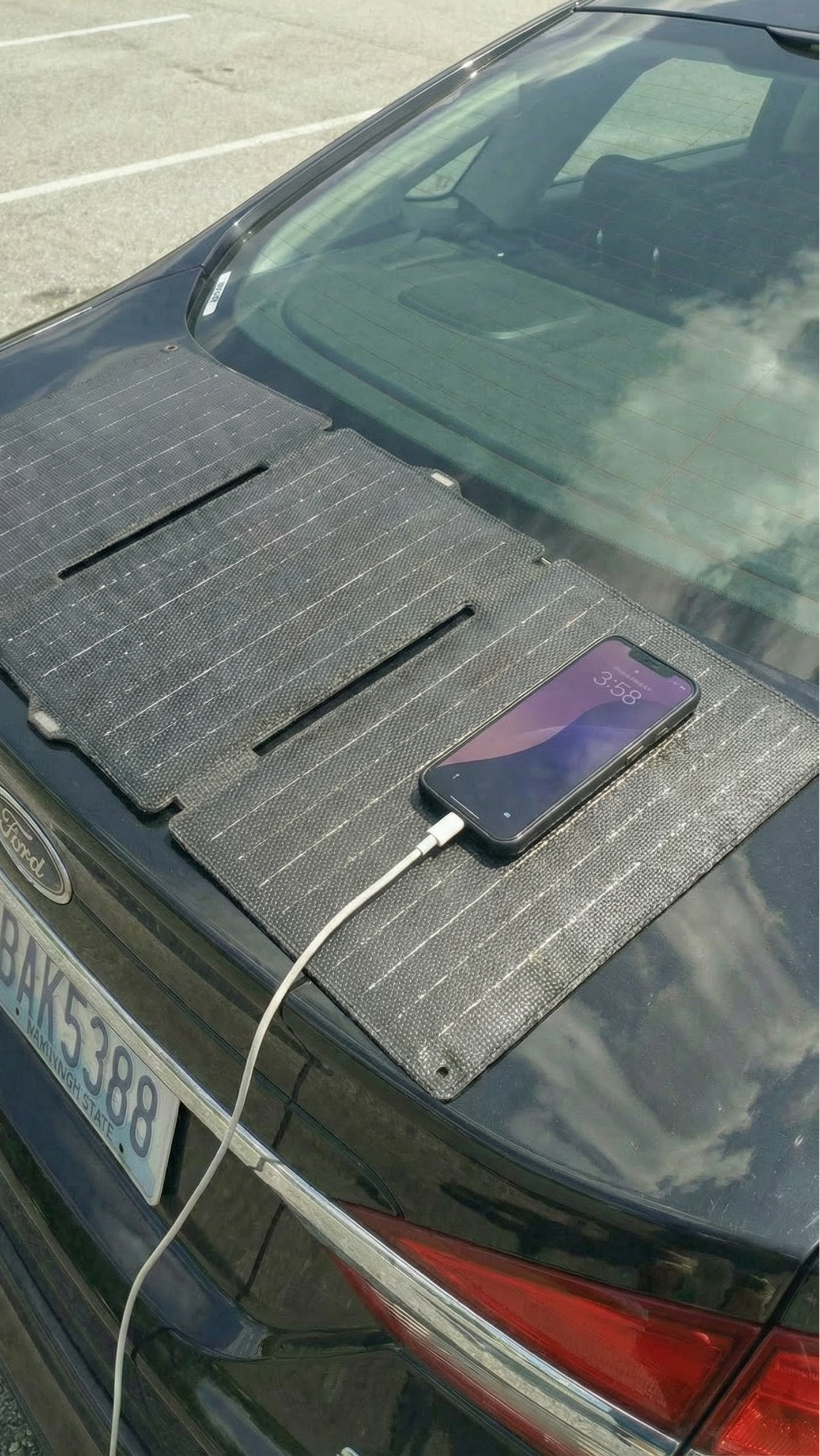 Phone charging from a solar panel attached to a car's roof.