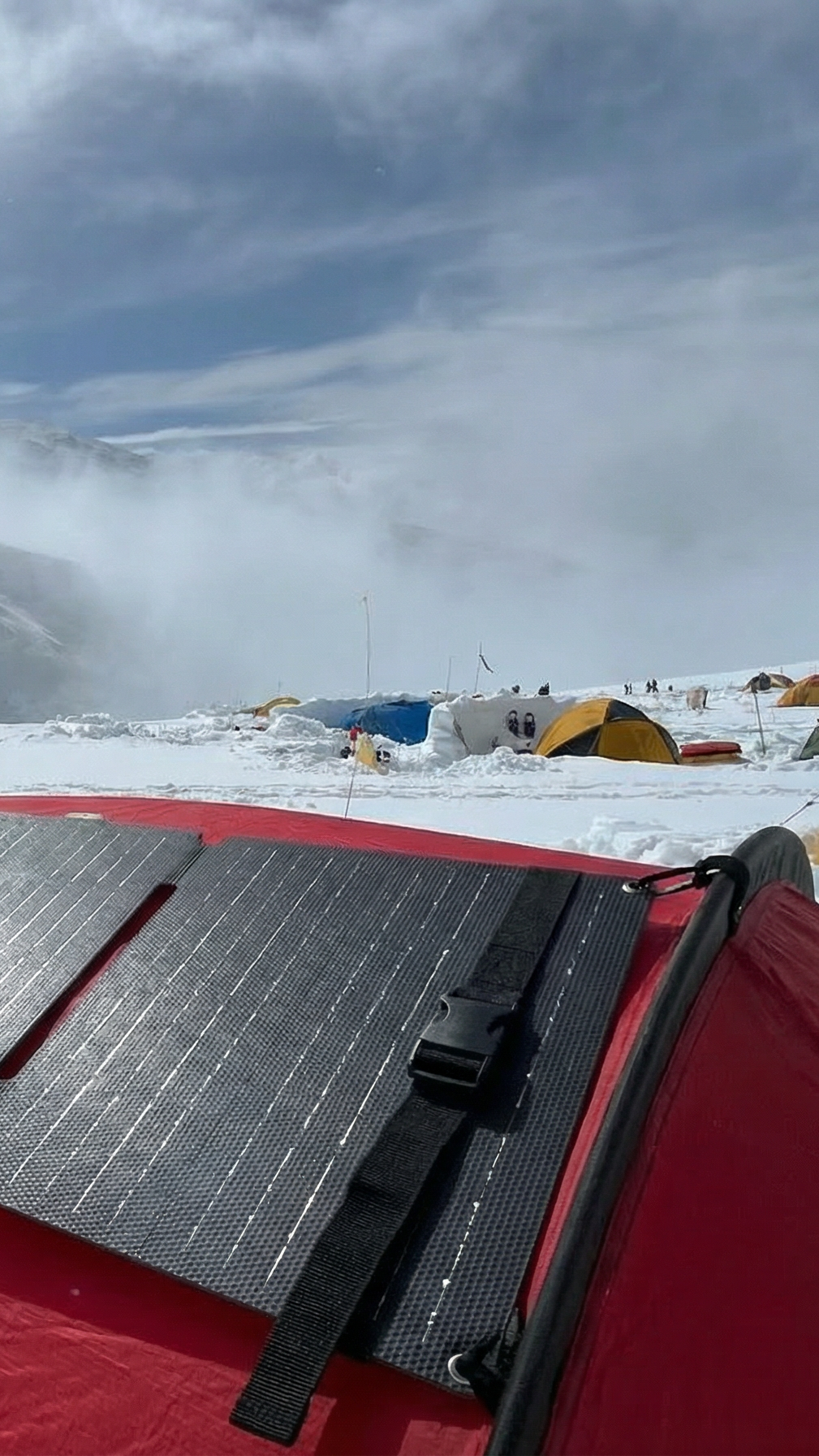 Solar panel on a red vehicle in a snowy mountainous area