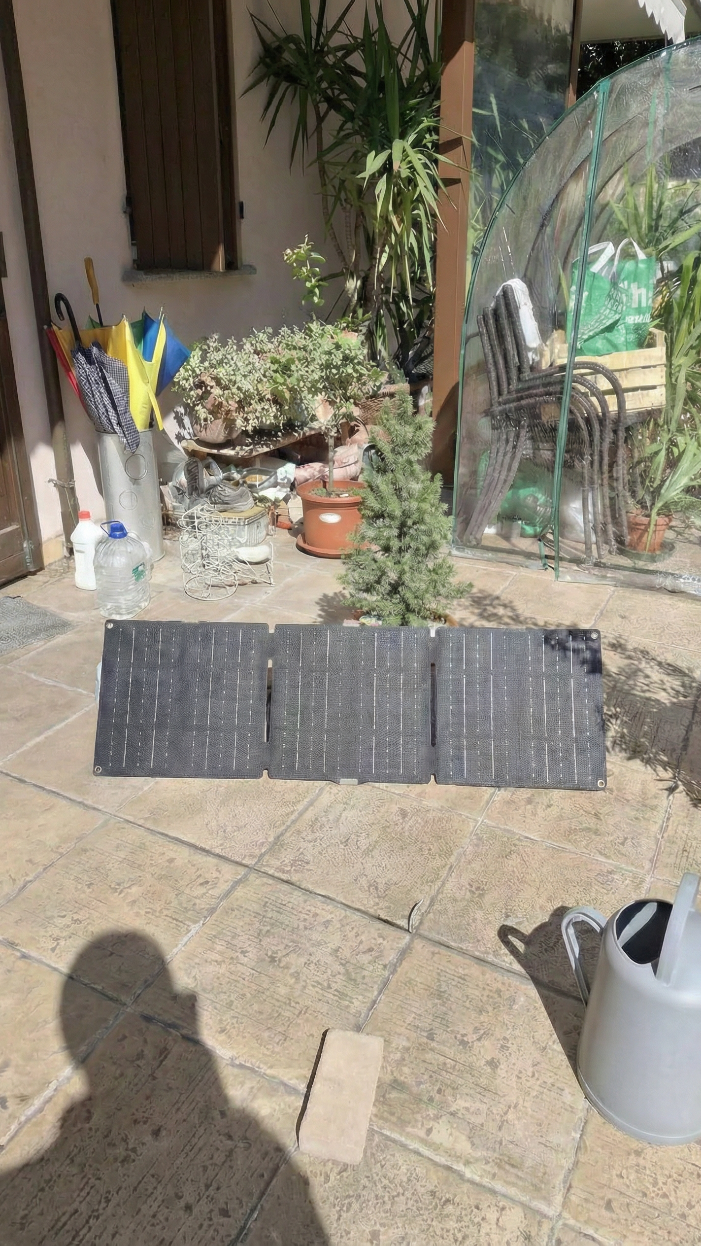 Solar panel on a patio with plants and outdoor furniture in the background