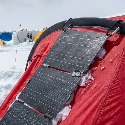 Solar panel attached to a red vehicle in a snowy landscape
